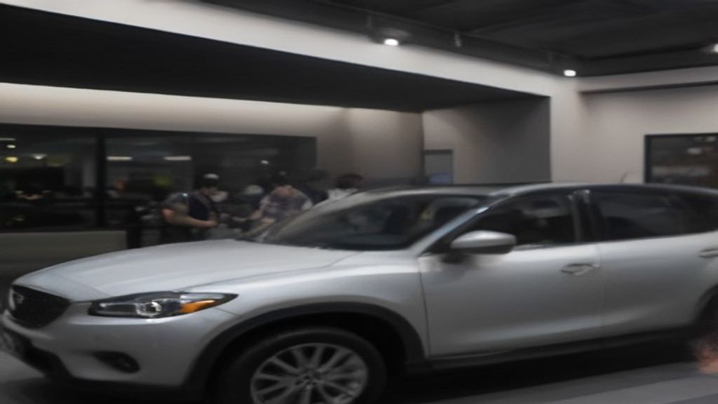 Pasangan muda Indonesia tersenyum bahagia menerima kunci mobil Mazda CX-5 2014 di depan showroom HK MOBILINDO.